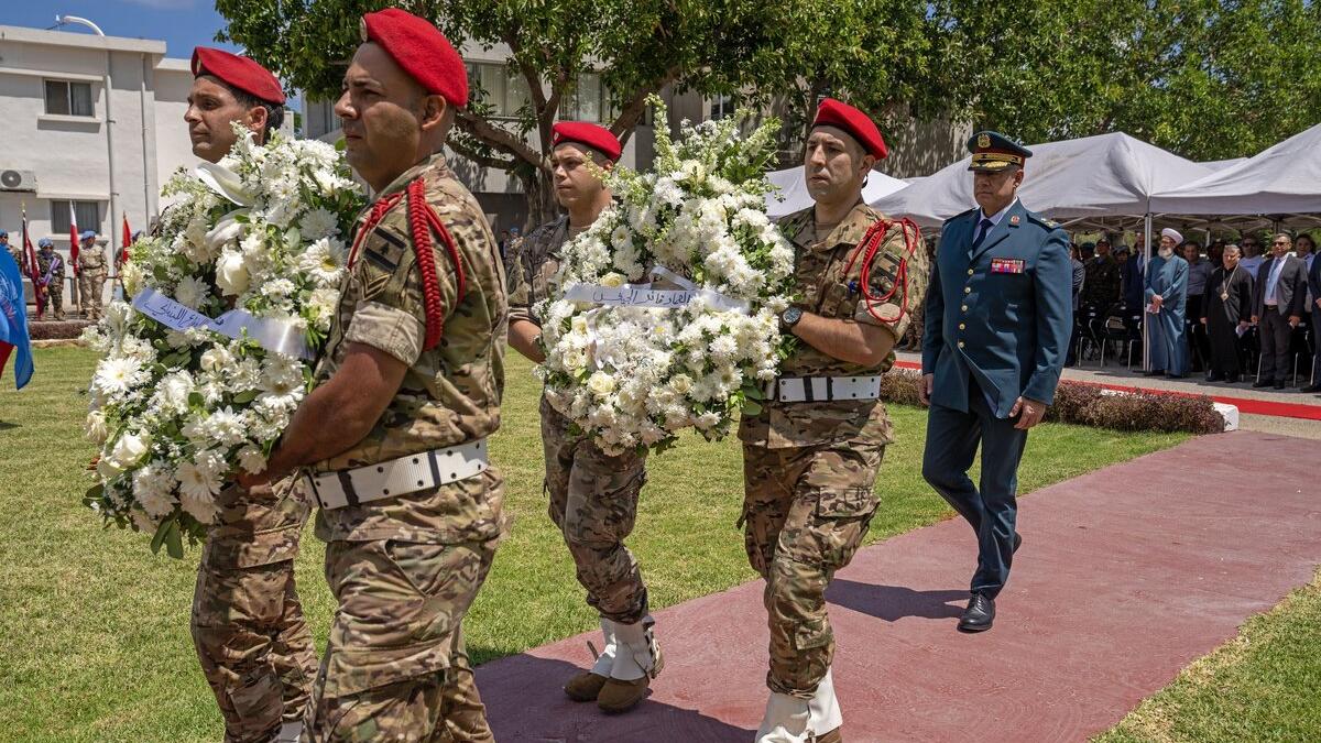 Peacekeepers carry flowers.